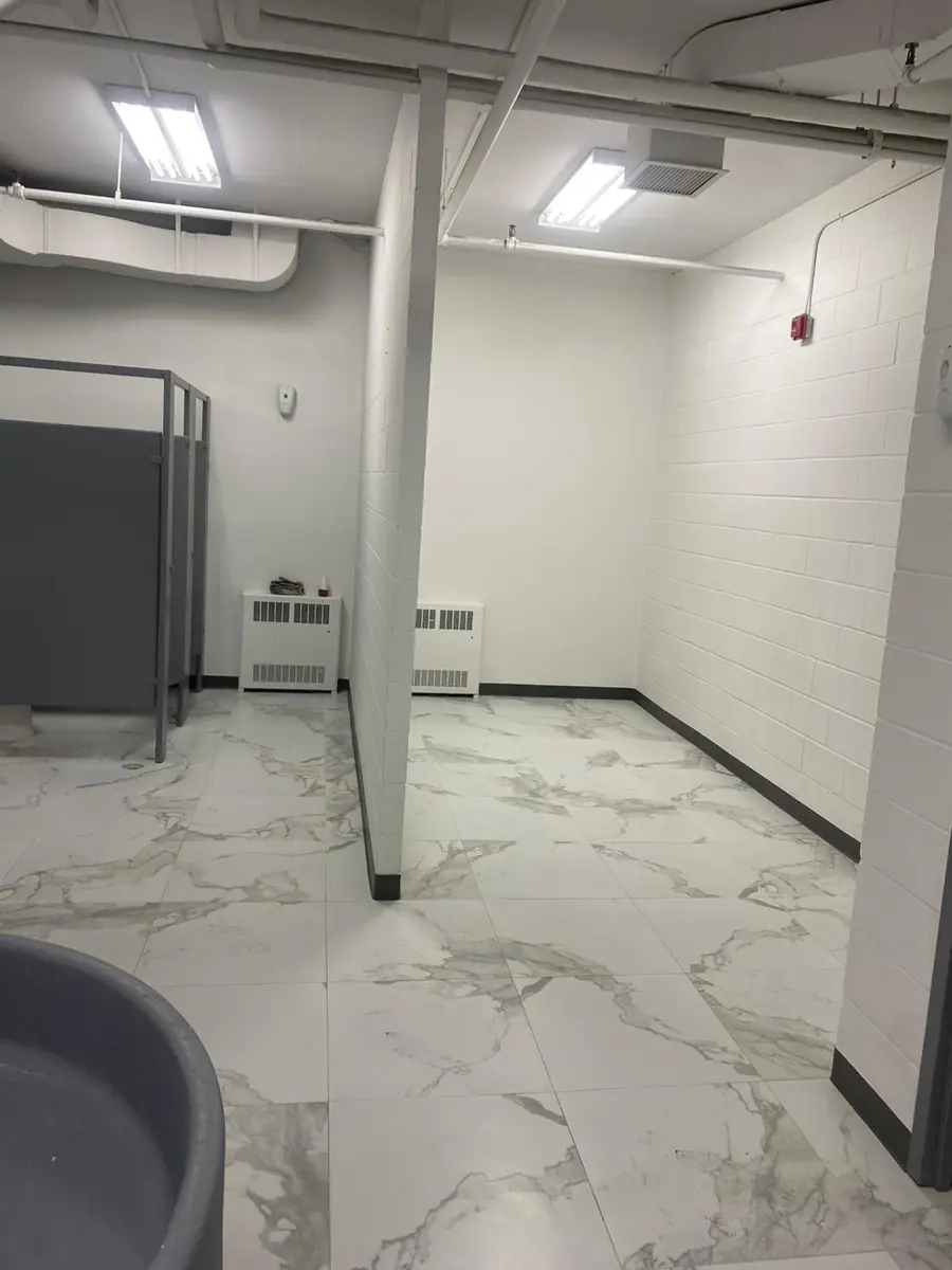 Finished commercial washroom with white marble-look floor tiles
