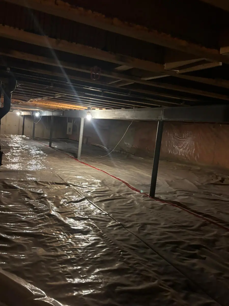 Crawlspace with support posts and protective ground covering